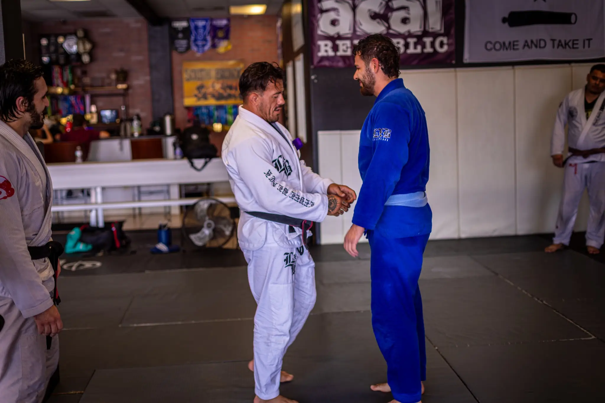 Teammates sharing respect at a belt promotion at Peerless Jiu Jitsu Academy in Corona, CA