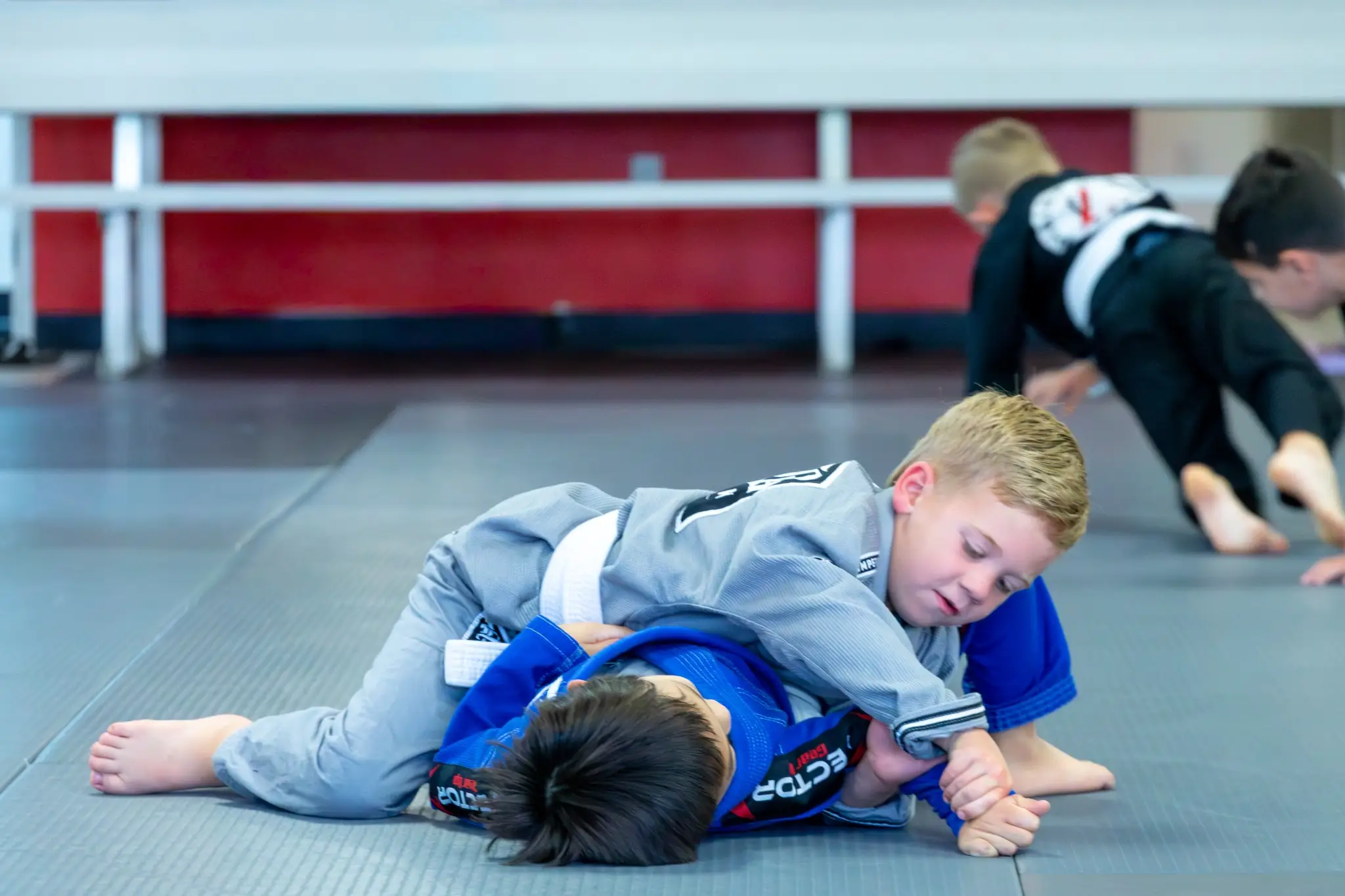 Young kids grappling during a youth Jiu Jitsu class at Peerless in Corona, CA