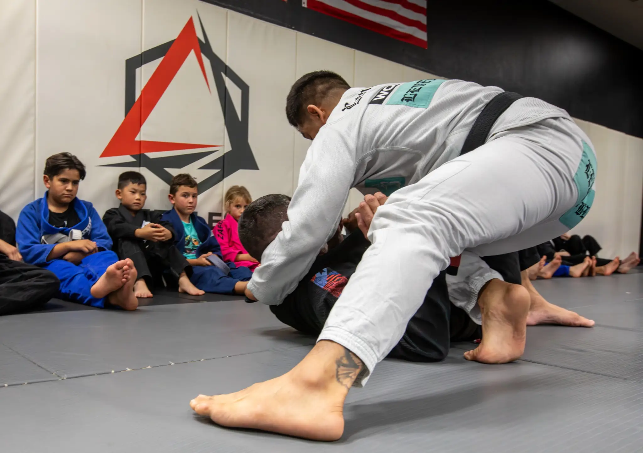 Black belt instructor teaching a kids Jiu Jitsu class at Peerless in Corona, CA